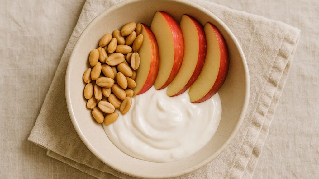 “Healthy snack bowl with peanuts, apples, and yogurt promoting gut health”