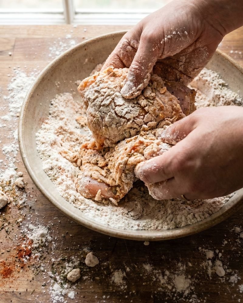 Double dredging chicken in seasoned flour for extra crispy broasted chicken crust