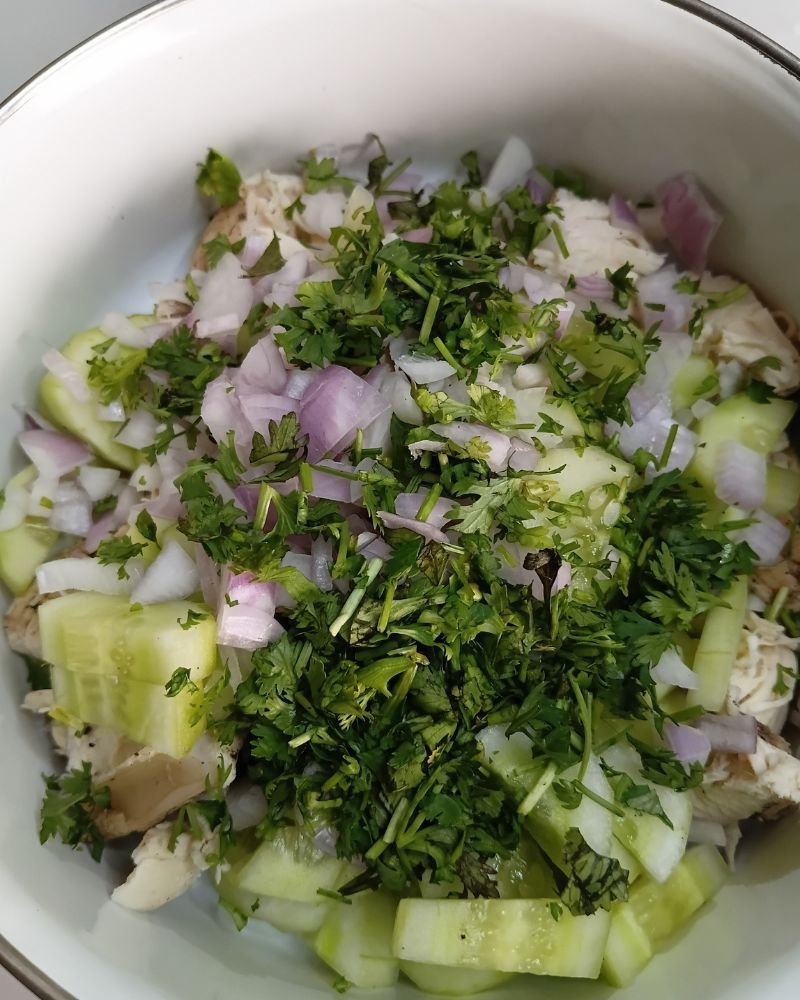 Add the chicken, cucumber, onion, and herbs to a large mixing bowl.