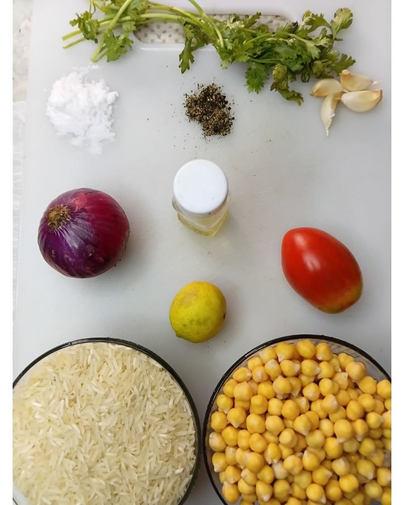 Ingredients for chickpea rice recipe including basmati rice, chickpeas, red onion, garlic, tomato, parsley, lemon, olive oil, and spices.